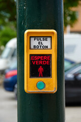 Traffic light button at a pedestrian crossing to press and wait for it to turn green with text in Spanish