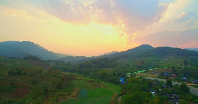 .Beautiful sunset on the hill amid the mountain range with the setting sun in Chiang Rai..Sunbursts flashed in the mountains range in beautiful sunset..Majestic sunset or sunrise landscape.