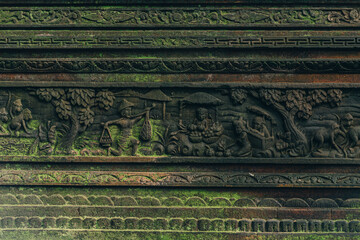 Close up shot of carved stone wall with moss in sacred monkey forest. Balinese architecture carving...