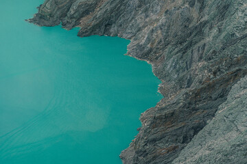 Top view of blue lake in the mountains. Scenic beautiful view of lagoon surrounded by hills