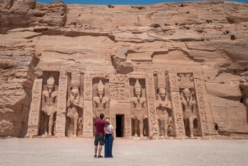 Young couple embraced, on their backs, enjoying the temple of Abu Simbel on her trip through Egypt....