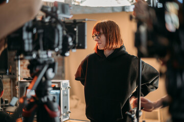 The director is a woman at work on the set. The director works with a group or with playback during...