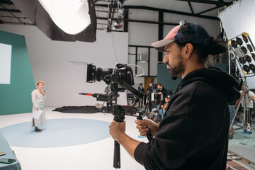 Director of photography with a camera in his hands on the set. Professional videographer at work on filming a movie