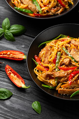 Stir fry chow mein noodles with pork and vegetable in black bowl. asian style food
