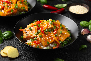 Homemade Stir Fry Tofu with Vegetables and Rice in black bowl.
