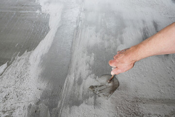 Smoothing concrete screed during house construction.