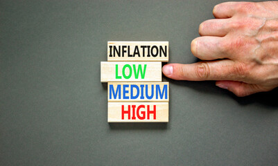 Low inflation symbol. Concept word Inflation low medium high on wooden block. Businessman hand. Beautiful grey table grey background. Business time to low inflation concept. Copy space.