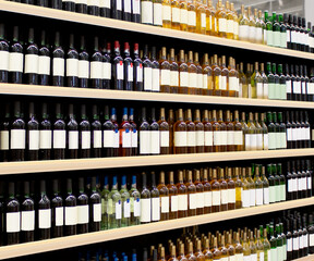 Vine bottles on shelf. Red and White vine bottles on shelves in supermarket interior. 
Suitable for presenting new Vine bottles and new brand label among many others. 
