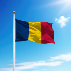 Waving flag of Chad on flagpole with sky background.