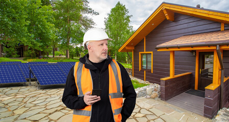 Solar panel installer. Man near country house. Cottage with mini power plant. Specialist after...