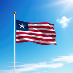 Waving flag of Liberia on flagpole with sky background.