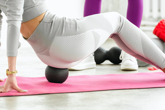 Slim woman training with yoga coach. Private lessons with personal trainer, fitness instructor. Workout, exercises at home on fitness mat. Sports equipment, resistance rubber, massage peanut ball