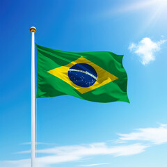Waving flag of Brazil on flagpole with sky background.
