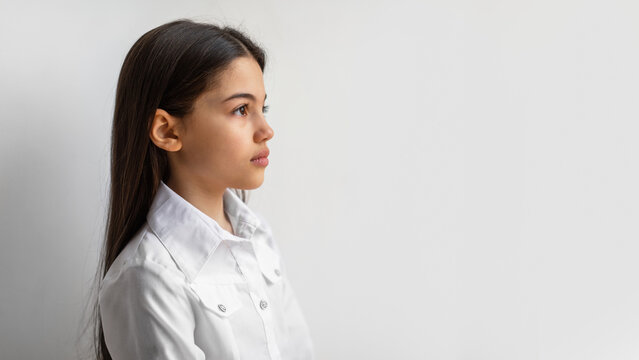 Profile Portrait Of Serious Arabic Preteen Girl Against White Wall