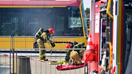 Firemen and burnt tram transport. Fire brigade action.