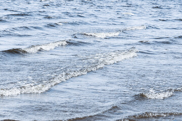 Background image: Waves on the sea, restless water surface, waves running ashore