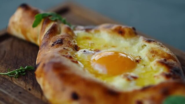 Caucasian Georgian cuisine, Adjarian khachapuri with fresh egg, close-up