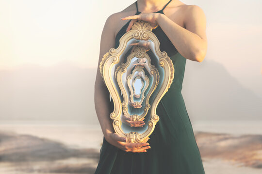 woman holding a mirror reflecting a surreal image of herself in loop, surreal concept