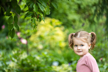 toddler girl with a bully face is outdoors among nature - obrazy, fototapety, plakaty