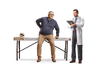 Doctor writing a document and a mature man with a lower back pain sitting on a therapy bed