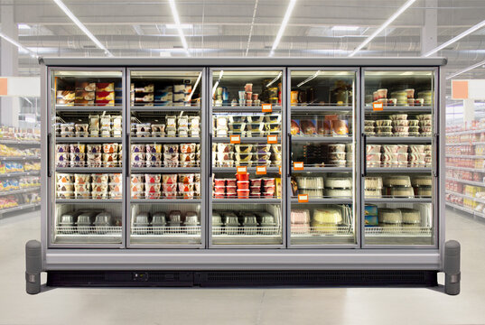 Ice cream and birthday cakes in a glass door freezer at supermarket. Suitable for presenting new packaging among many others. Front view.