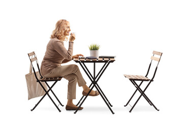 Woman enjoying a cup of coffee and sitting at a table alone