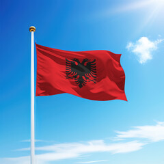 Waving flag of Albania on flagpole with sky background.