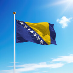 Waving flag of Bosnia on flagpole with sky background.