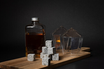Squared whisky bottle on a wooden serving trey with icelandic granite whisky stones and and diamond...