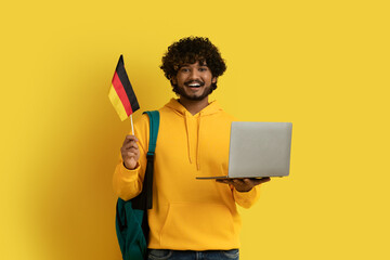 Happy indian man holding laptop and flag of Germany