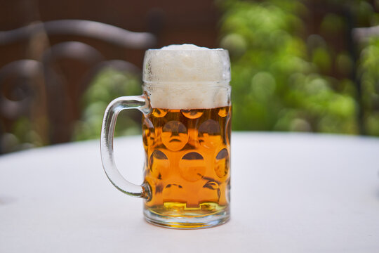 Close up picture of pint or half liter mug of czech pilsner lager beer served outside on table in beer garden during hot summer sunny day. Refreshment drink typical for beer culture of Czech republic.