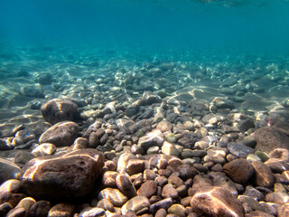 Vista subacquea del Mar Jonio, Isola delle Sirene, con pietre e sassolini