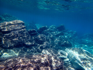 Vista subacquea del mare dell'Isola delle Sirene con acqua blu e rocce