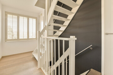 a staircase with white railings and wood flooring in a modern style home entryway to the stairs is...