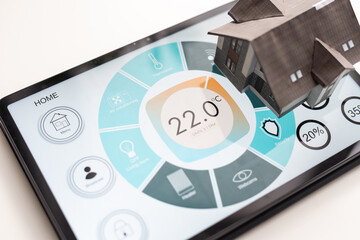 Small house model is on screen tablet and icons home electronics devices connecting with wireless....