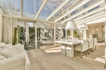 a living room with wood flooring and skylights above the glass door leading to an open patio area...