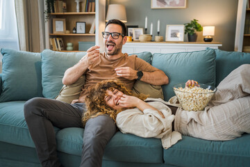 Couple caucasian man and woman sit at home on sofa bed watch tv movie
