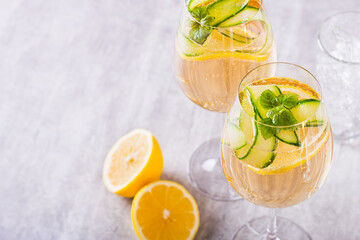 Hugo spritz sparkling cocktail with champagne, cucumber, lemon and mint in wine glasses