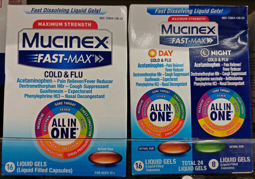Mucinex Cold and Flu medicine packages in a supermarket