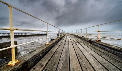 Wooden pier and cloudy skies over the water