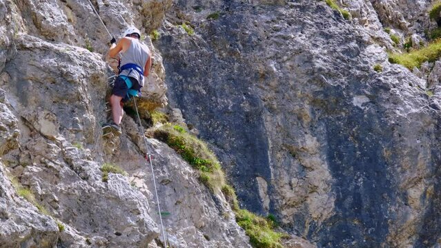 mature man, rock climber in body harnesses feature life-safety climbs in Seefeld in Tirol, extreme lifestyle of people, mountaineering, via ferrata in mountains, life insurance in extreme sports
