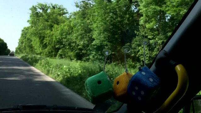 Fluffy dice dangle from the windshield. dice for dice