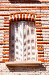   Closed, metal, window shutters with red brick surround, detail, on historic,1300's building