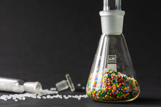 Plastic factory laboratory. Glass flasks with colored dye in granules for plastics. polymer industry.