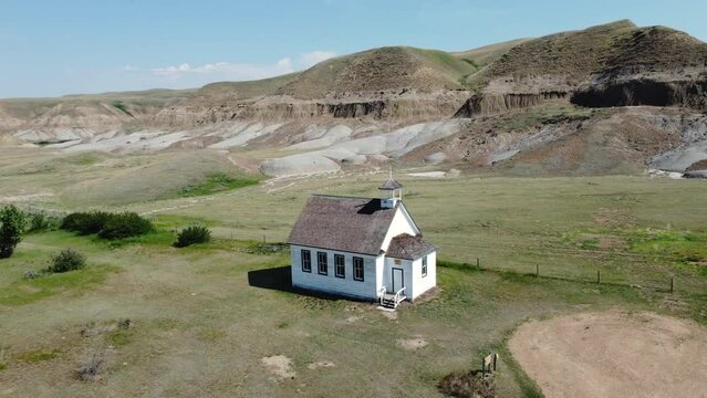 Zoom out from old wooden church buildins in the badlands ghost town of Dorothy, Alberta. 