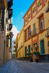 Fototapeta na wymiar 24.05.2023, Cadiz, Spain: Narrow streets of Cadiz with shops, cafes, restaurants and souvenir shops and colorful houses