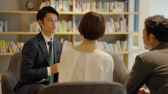 夫婦に営業をするビジネスパーソン