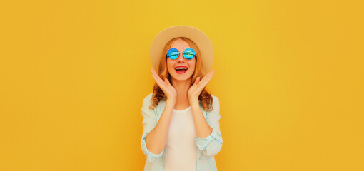 Portrait of happy excited surprised young woman wearing straw hat and sunglasses on yellow...