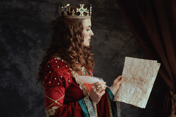 medieval queen in red dress with parchment and crown
