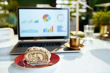 Closeup on table in modern office with piece of cake